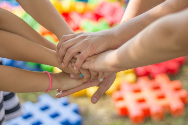 Mehrere Hände liegen übereinander und symbolisieren, dass Kirsikka Lansmann sich für die Familien in Gifhorn und Wolfsburg stark macht.